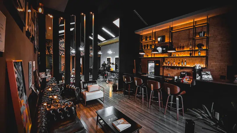Lounge da Smart Man com sofás Chesterfield e bar iluminado